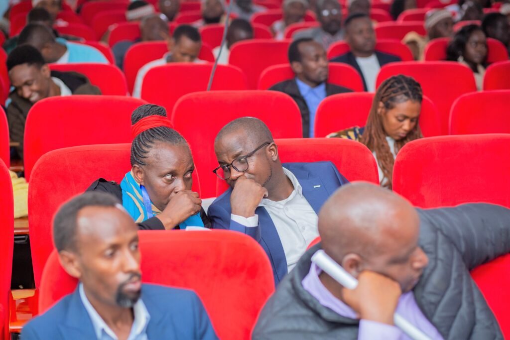 Some members of the audience sitting down in theatre hall.